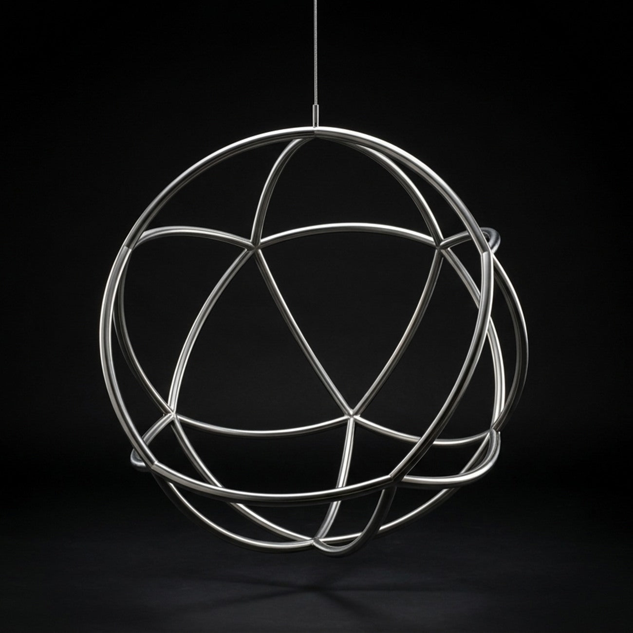 Kora as raw polished stainless steel only: a hanging sphere of crossing round tubes with nothing inside it, on a dark studio background